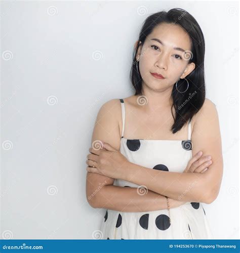 Portrait Of Beautiful Adult 40 Years Old Asian Woman In Polka Dots Dress With Arms Crossed And