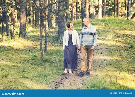 Senior Couple Walking On Forest Trail Holding Hands Stock Photo Image