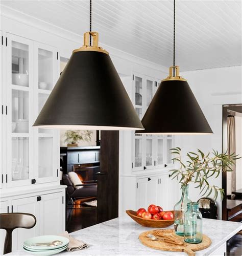 Light up your room with chandeliers, pendants & more. Large black and gold pendant lights over white marble ...