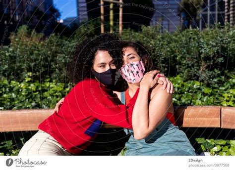 Lesbian Couple With Sunglasses Embracing And Relaxing On A Park Bench A Royalty Free Stock