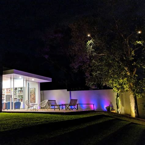 This rooftop garden by john cullen lighting has an outdoor lighting scheme that uses spot lights, deck lights, tabletop lanterns, and an outdoor fireplace to create multiple sources of light. DIY Outdoor Lighting Designs - Holman Industries