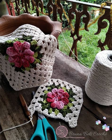 Two Crocheted Potholders With Flowers On Them And Yarn Next To Them