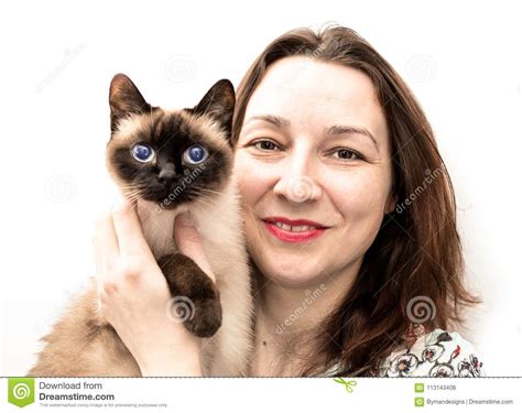 Beautiful Woman With The Siamese Cat In Her Arms Smile To The Ca Stock