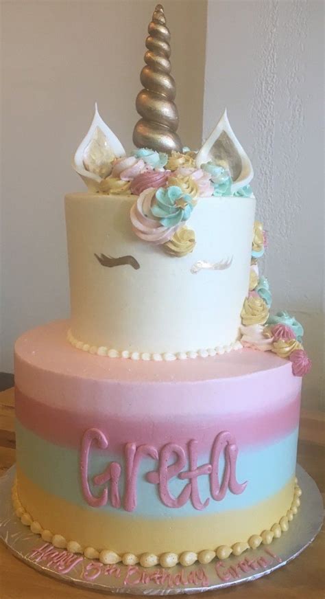 A Three Tiered Cake Decorated With An Unicorns Head And Name On It
