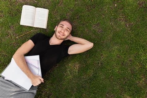 Estudiante Universitario Tomando Un Descanso En El Césped Foto Gratis