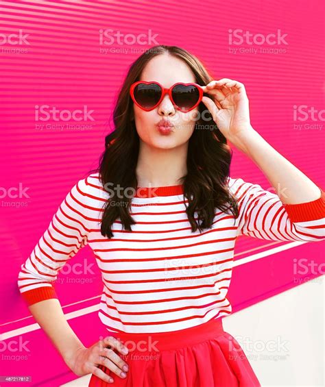 Portrait Of Pretty Sweet Woman In Red Sunglasses Blowing Lips Stock