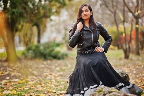 Красивая индийская девушка в черном платье сари и кожаной куртке