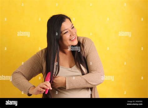 40 Year Old Latina Woman Brushes Her Straight Hair With Difficulty Because It Is Already Too