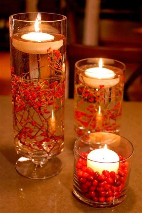 Two Glass Vases Filled With Red Berries And Candles