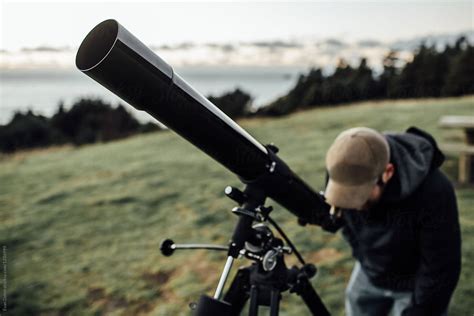Man Using Telescope At Dusk By Stocksy Contributor Evan Dalen Stocksy