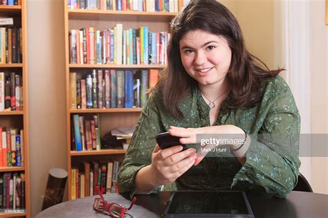 Woman With Asperger Syndrome Working With Her Smart Phone And Tablet From Home Office High Res