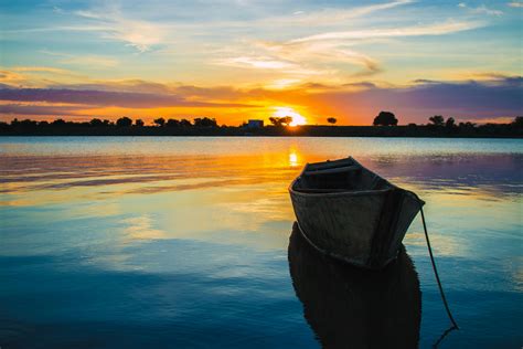 A Wooden Boat On Water During Sunset · Free Stock Photo