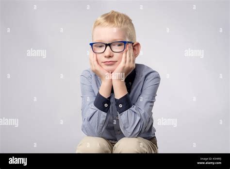 Portrait Of Caucasian Blond Boy In Glasses Looking With Bored Facial