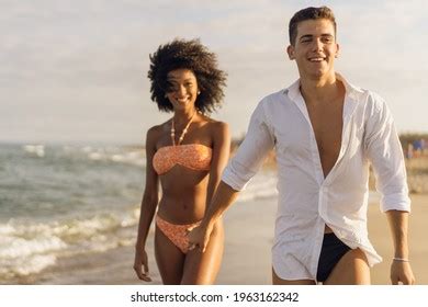 Interracial Couple Walking On Beach Smiling Stock Photo 1963162342