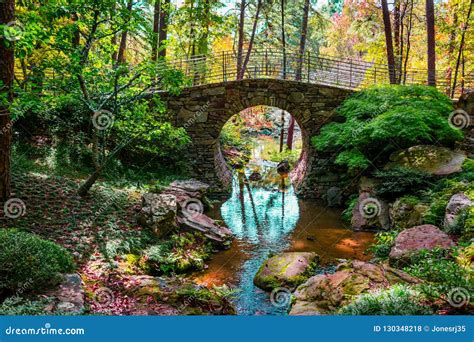 Scenic Round Stone Bridge Over A Stream With Fall Colors Emerging Stock