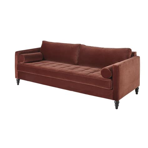 A pretty boho living room with a terracotta statement wall, a grey sectional, a rattan chair and some potted plants and round tables. Terracotta 3-Seater Velvet Sofa Malik | Maisons du Monde