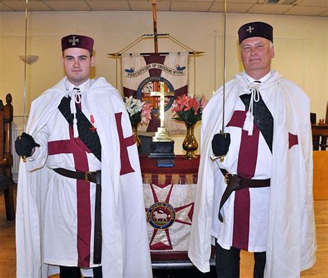 two men dressed in white and red standing next to each other at a church alter