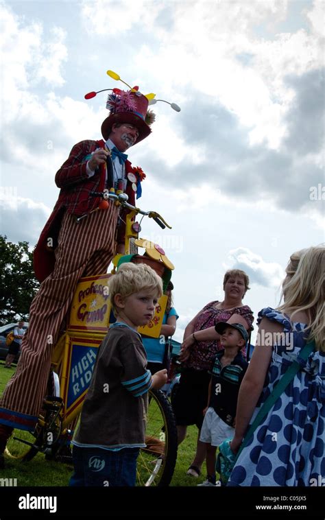 Clown On Stilts With Children Onlookers At Brailes Village Show