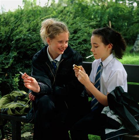 Young Teenage Girls Lighting Cigarettes Outdoors Photograph By Damien