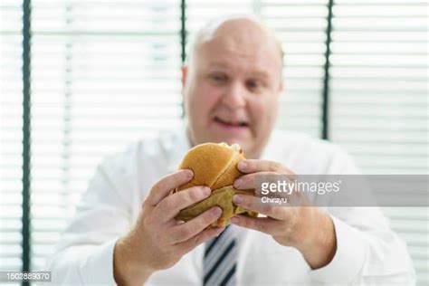 Fat Guy Eating Cheeseburger Photos And Premium High Res Pictures