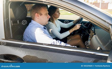 Portrait Of Beautiful Female Driver And Male Passenger Riding In Car