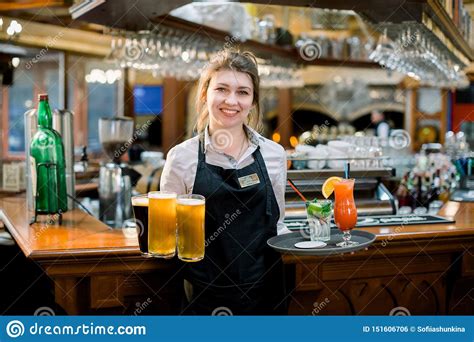 Smiling Friendly Waitress Serving A Pint Of Draft Beer In A Pub. Portrait Of Happy Young Woman ...