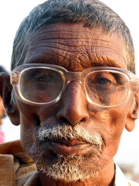 An Old Man Wearing Glasses Having All His Hair And A Furrowed Face