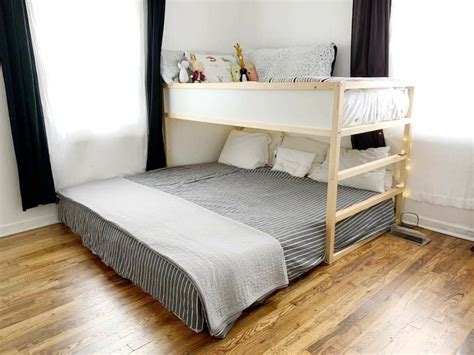 A Bunk Bed In The Corner Of A Room With Wood Flooring And Black Curtains
