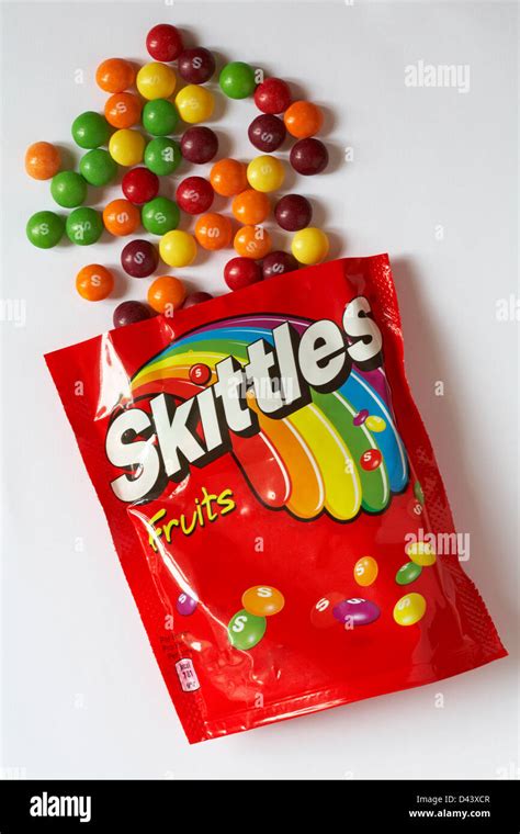 Packet Of Skittles Fruits Sweets Opened With Contents Spilled On White