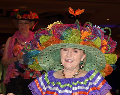 An Older Woman Wearing A Colorful Hat And Dress