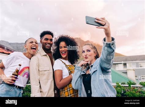 Friends Taking A Group Selfie Outdoors Four Happy Friends Posing For A
