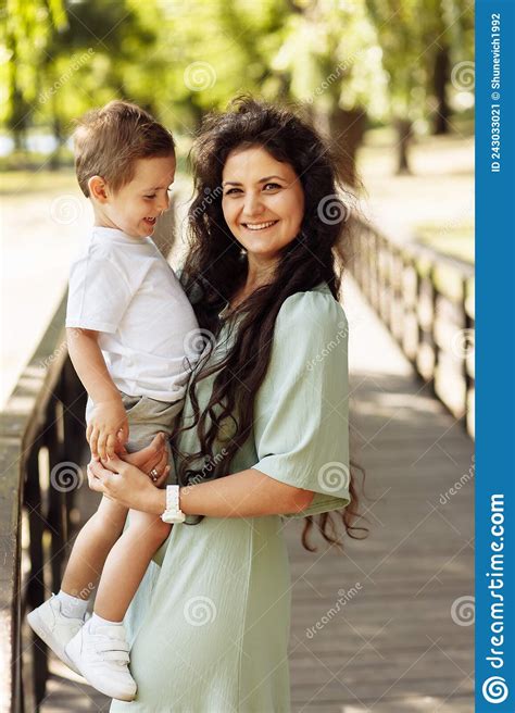 Portrait Of Adorable Mother With Overjoyed Son At The Park Beautiful Woman Hold In Arms Little