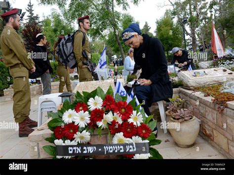 An Israeli Woman Prays By The Grave Of A Fallen Soldier On Memorial Day