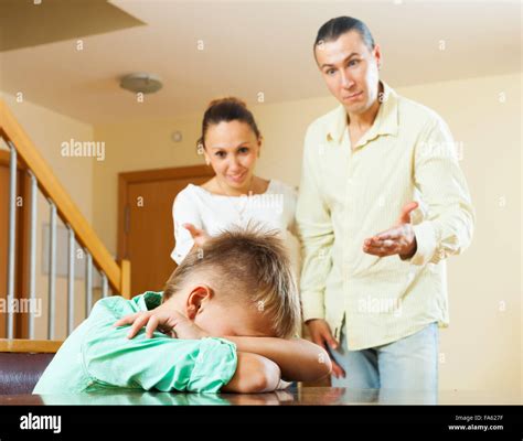 Parents Scolding Her Teenage Child In Home Interior Focus On Boy Stock