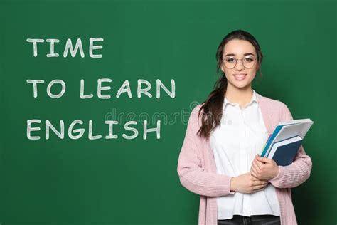 Teacher Near Green Chalkboard With Text Time To Learn English Stock