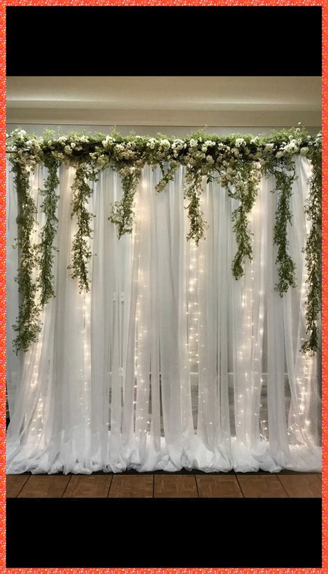The Curtain Is Covered With Greenery And Lights