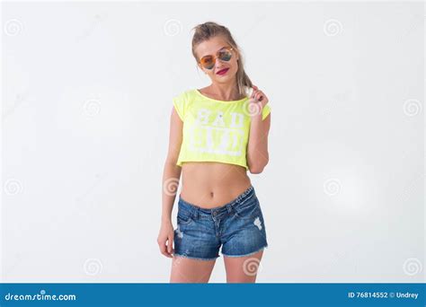 Young Woman Posing Alone Wearing Bright Yellow T Shirt Denim Shorts With Naked Stomach