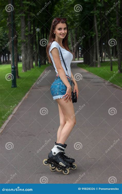 Beautiful Smiling Girl In Denim Shorts Rollerblading Stock Photo