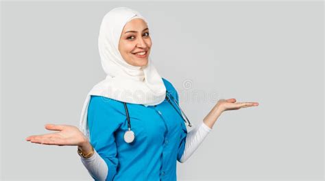 Beautiful Modern Muslim Doctor Or Nurse In Hijab On A Gray Background