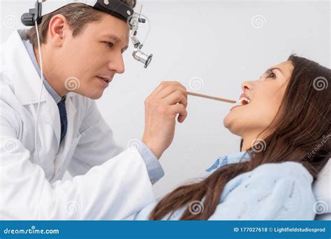 Otolaryngologist In Ent Headlight Examining Throat Stock Photo Image