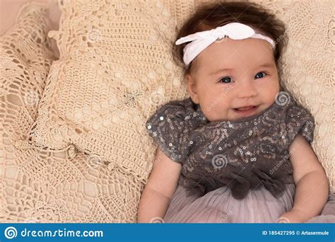 Portrait Of A 4 Month Cute Baby Girl Wearing White Headband And Grey