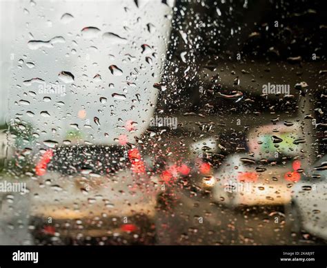 Traffic In Rainy Day With Road View Through Car Window With Rain Drops