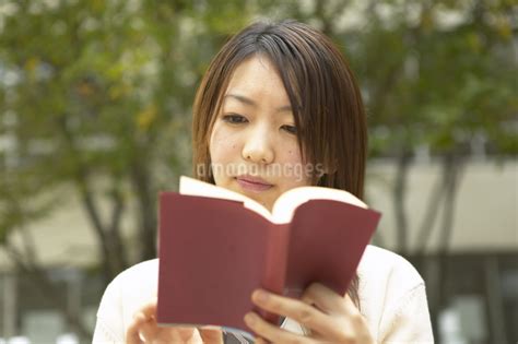 校庭で本を読む女子高校生の写真素材 Fyi03866643 ストックフォトのamanaimages Plus