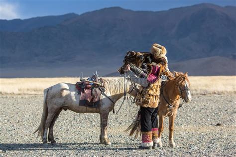 Kazakh Eagle Hunter Berkutchi With Horse While Hunting To The Hare With