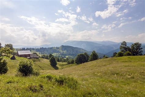 Village Houses On Hills With Green Meadows In Summer Day Stock Photo