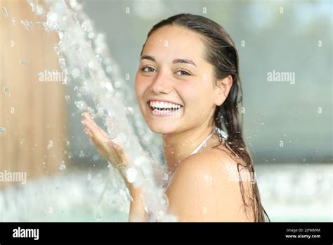 Happy Woman Bathing In Spa Under Water Jet Looking At Camera Stock