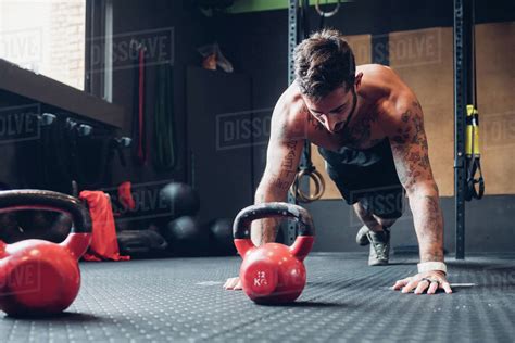 Young Man Training In Gym Doing Push Ups On Floor Stock Photo Dissolve