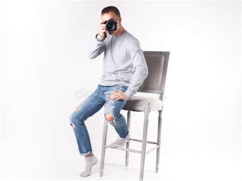 Photographer Man Sitting On A Chair Looking At The Camera Stock Photo