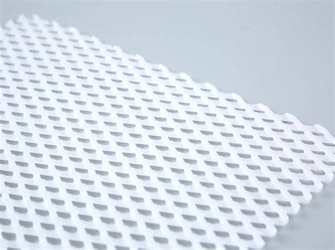 A Piece Of White Plastic Mesh With Diamond Meshes On The Gray