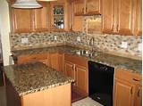 The kitchen island is made of oak with a thin, black stone countertop. Golden Oak Cabinets Granite Countertops | portofino | For ...
